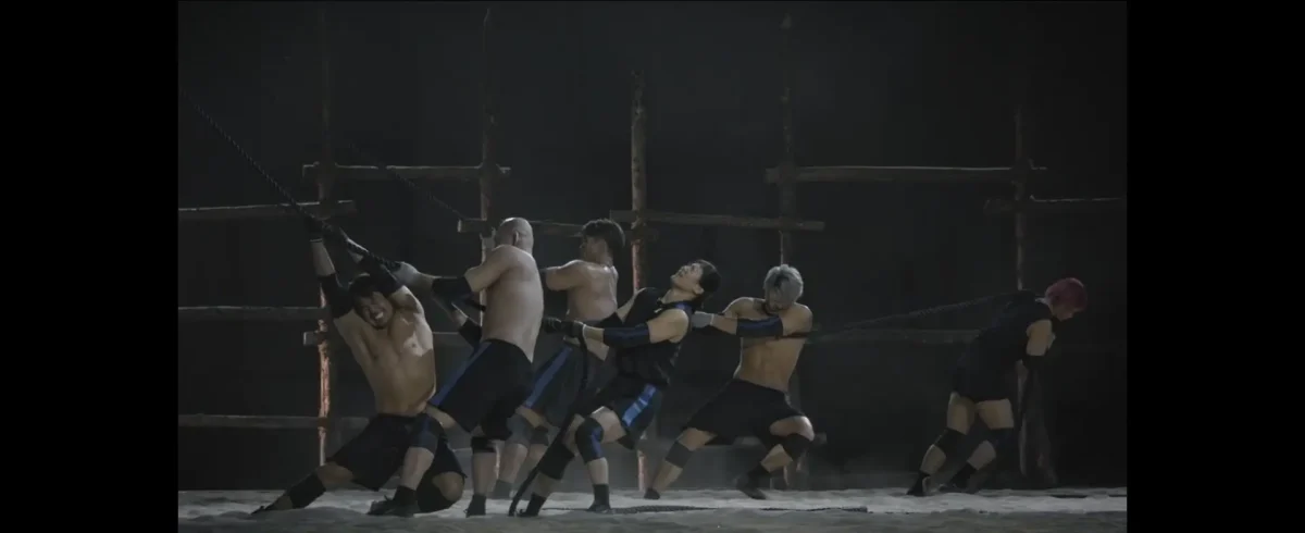 Equipe japonesa tentando baixar o portão e demonstrando frustração ao não conseguir