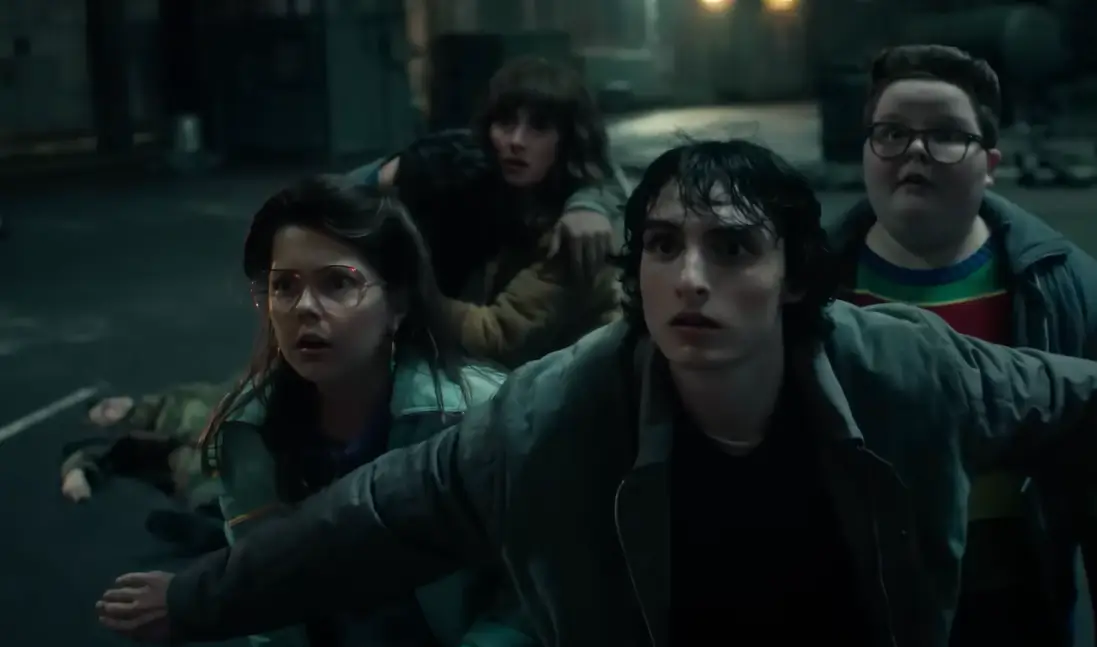 Os personagens de Stranger Things olhando para algo fora da cena com expressões de choque.