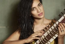 Anoushka Shankar toca sitar durante apresentação ao vivo em palco iluminado