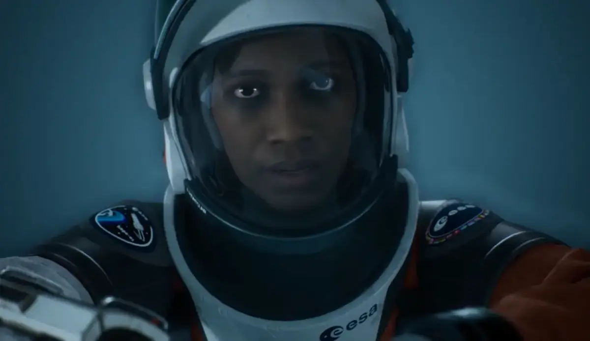 Ariane Montclair com traje da ESA e patch Hope-01 em cena cinemática de Aphelion, aventura sci-fi da DON'T NOD