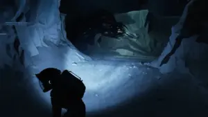  Cena de gameplay de Aphelion com astronauta agachado em silhueta confrontando o Nemesis, a criatura alienígena que habita Persephone, em passagem gelada com iluminação dramática — ilustrando as sequências de stealth do jogo de ação e aventura da DON'T NOD lançado em abril de 2026.