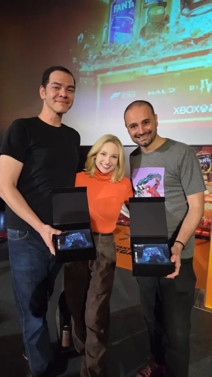Fanta e Xbox celebram 25 anos do console com evento temático 5 Jefão Calheiro, a youtuber e apresentadora Haru e Rodrigo Fernandes segurando o controle Sky Cipher do Xbox sorteado no evento dos 25 anos do console
