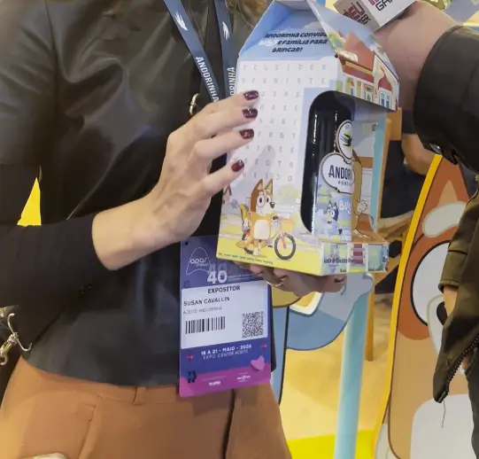 Susan Cavallin explica escolha da Bluey para linha infantil da Andorinha 1 Susan Cavallin, gerente de marketing da Andorinha, segurando embalagem especial do azeite Bluey no estande da APAS Show 2026