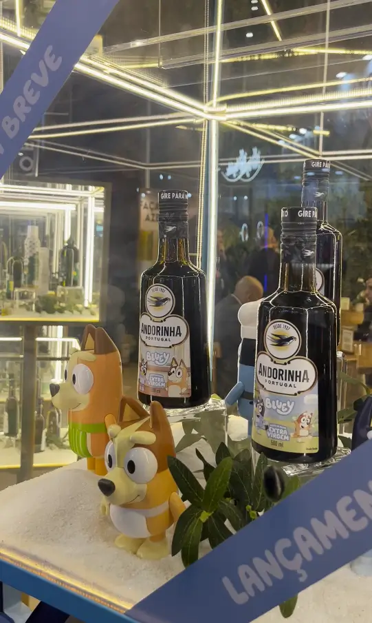 Susan Cavallin explica escolha da Bluey para linha infantil da Andorinha 2 Garrafas do azeite Andorinha edição especial Bluey expostas em vitrine com bonecos dos personagens na APAS Show 2026