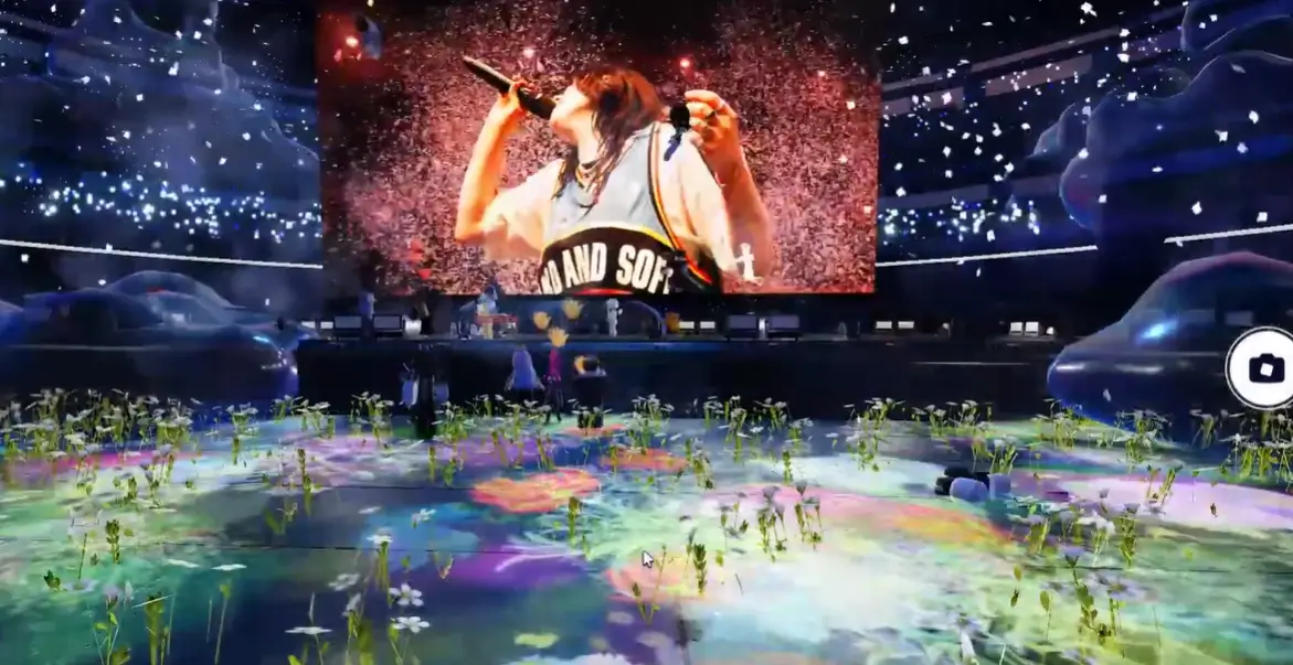Avatares do Roblox assistem à exibição do documentário de Billie Eilish no telão do The Block, com cenário de arena e iluminação de show