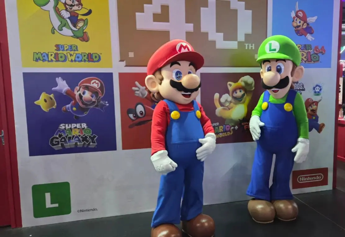 Nintendo e sua representação na gamescom latam 2026 2 Mascotes Mario, Luigi posando com visitantes no estande da Nintendo na gamescom latam 2026