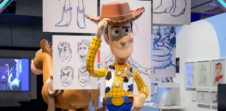 Estátua de Woody em tamanho real cercada por esboços de personagens da Pixar na exposição Toy Story ao Infinito e Além em São Paulo