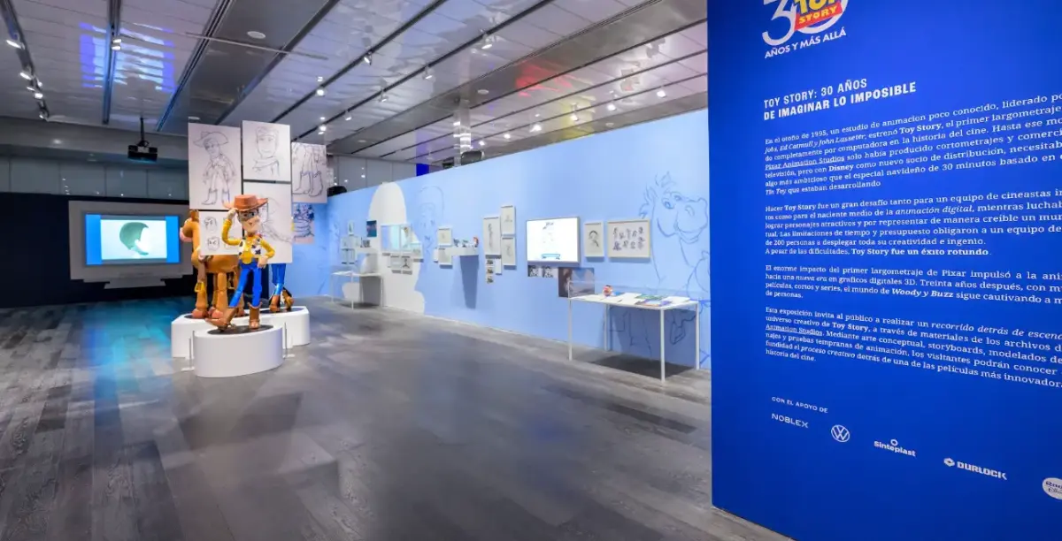 Toy Story ao Infinito e Além: exposição chega a São Paulo em maio 2 Vista panorâmica da exposição Toy Story ao Infinito e Além com estátuas de Woody e Bala no Alvo, painéis de storyboard e telas de animação