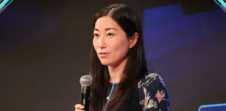 Zhen Fang, Vice-Presidente Internacional da Roblox, com microfone na mão em imagem de divulgação para palestra na gamescom latam 2026
