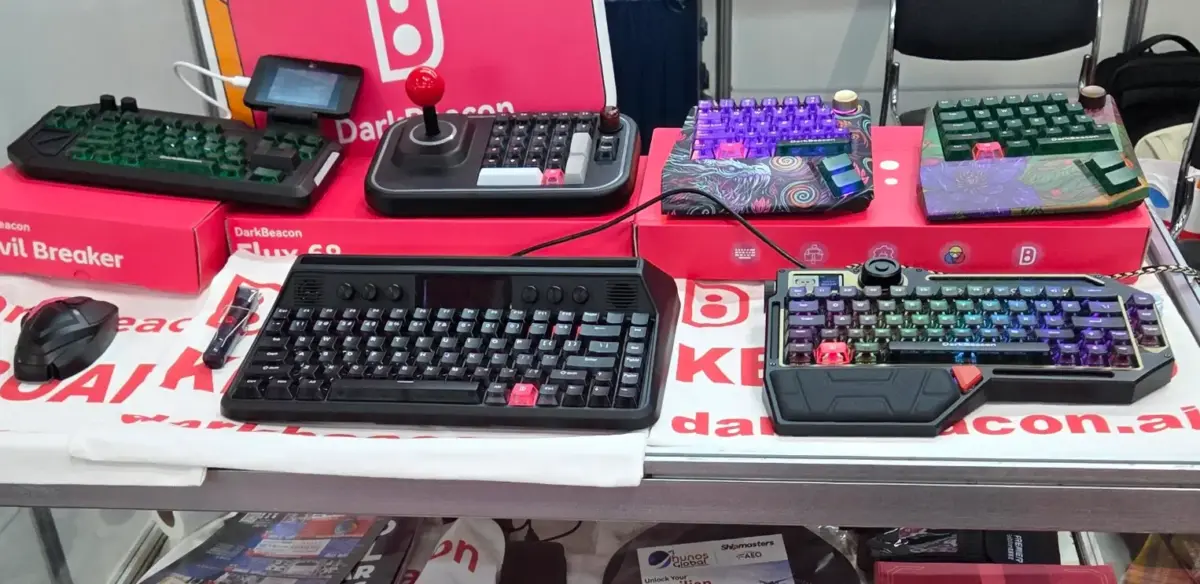 Mesa com diversos teclados mecânicos DarkBeacon, incluindo modelos retrô, estilo arcade e joystick na Eletrolar Show 2026