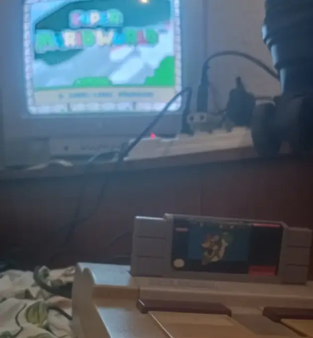 Quem se beneficia com o fim das mídias físicas nos games 1 Super Nintendo original com o cartucho de Super Mario World ligado em uma televisão de tubo, destacando a nostalgia das mídias físicas nos videogames.